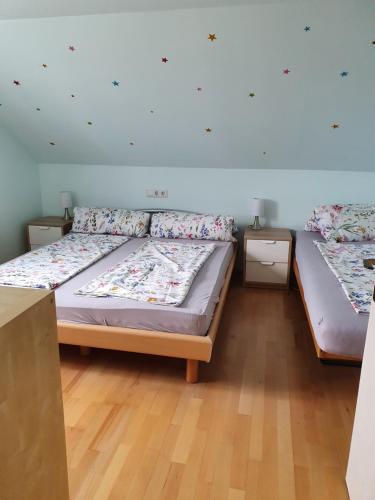 two twin beds in a room with wooden floors at Helene Hohenems, 4-12 P, Haus, 4 Schlafzimmer, Küche, Parkplatz, Garten, Wifi in Hohenems