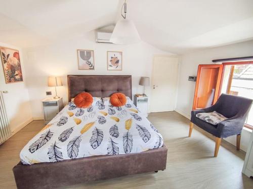 um quarto com uma cama e uma cadeira azul em Mansarda Balilla Centralissima vicinissima al mare em San Benedetto del Tronto