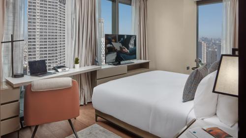 a hotel room with a bed and a desk with a computer at Oakwood Makati Avenue in Manila
