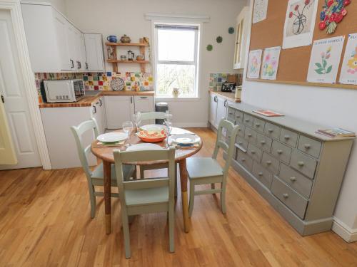 a kitchen with a table and chairs in a kitchen at Main Street View in Keighley