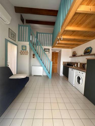 une cuisine avec un escalier et un lave-linge. dans l'établissement Le lagon vue dégagée, à Gruissan