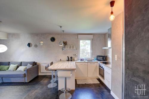 une cuisine et un salon avec un canapé et une table dans l'établissement Le Dahlia / Jardin Botanique, à La Riche