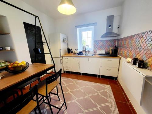 uma cozinha com uma mesa e uma bancada em Torre de Santiago - Guest House em Vila Praia de Âncora