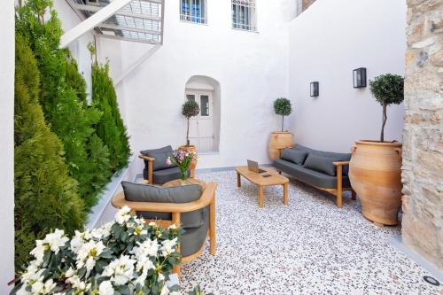 a patio with couches and tables and plants at Agora Suites in Athens