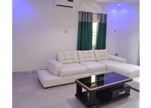 a living room with a white couch and a coffee table at YP-Made Luxurious 1 & 2 Bedroom Apartments in Eluju