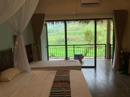 a bedroom with a large bed with a large window at Pu Luong Ecostay in Lũng Tiềm