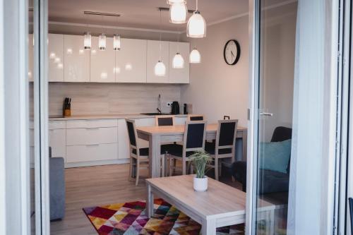 a kitchen and dining room with a table and chairs at Rezydencja Park Mielno in Mielno