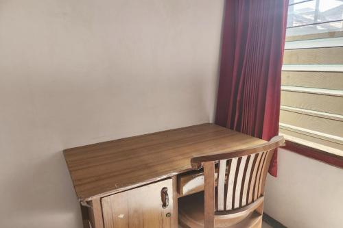 a wooden desk in a room with a window at OYO 93869 Regina Homestay Syariah in Surabaya
