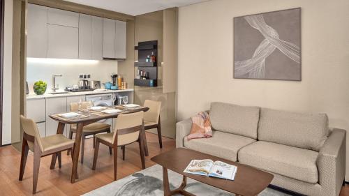 a living room with a couch and a table and a kitchen at Oakwood Makati Avenue in Manila