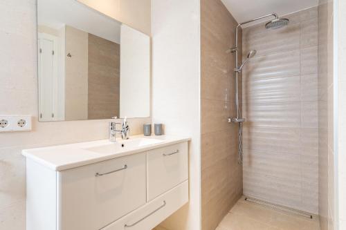 a white bathroom with a sink and a shower at The Tower Villa in El Toro