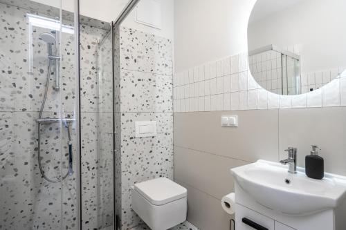 uma casa de banho com um lavatório e um chuveiro. em 33 Gdynia Oksywie - Apartament Mieszkanie dla 2 os em Gdynia