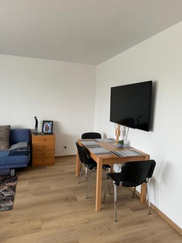 a room with a table with chairs and a television at City-See Central Apartment in Marl