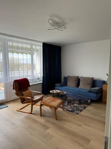 a living room with a blue couch and a chair at City-See Central Apartment in Marl