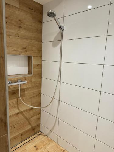 a shower in a bathroom with wooden walls at City-See Central Apartment in Marl