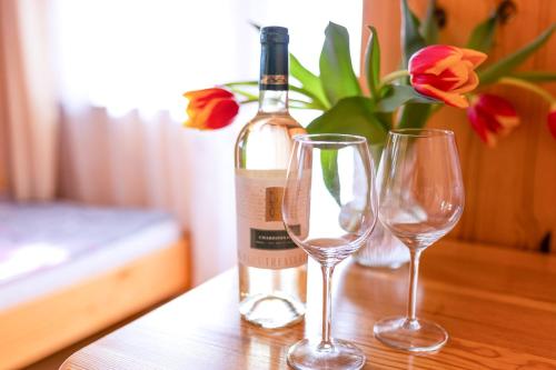 a bottle of wine and two wine glasses on a table at Willa Piękne Widoki in Ząb