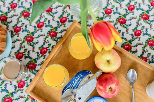 a wooden cutting board with two glasses of orange juice and apples at Willa Piękne Widoki in Ząb
