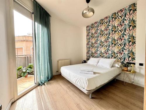 um quarto com uma cama e uma grande janela em House with terrace connected with Downtown&Airport em Barcelona