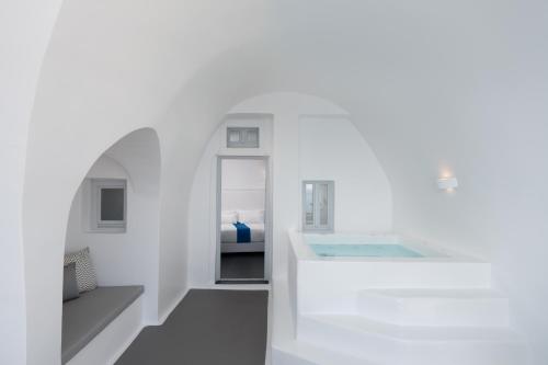 a white room with a sink and a bed at Katikies Villa Santorini - The Leading Hotels Of The World in Oia