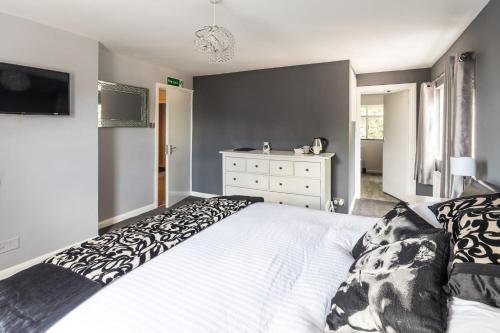 um quarto com uma cama branca e uma cómoda em The Cherry Tree Inn em Ticehurst