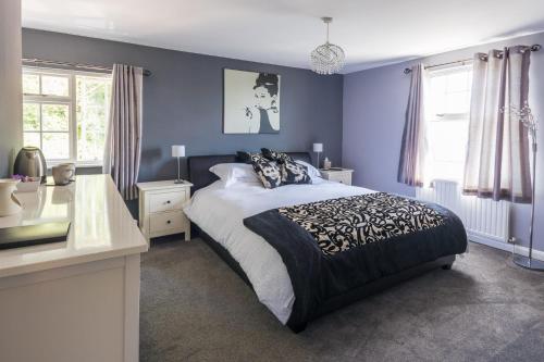 1 dormitorio con 1 cama grande y paredes azules en The Cherry Tree Inn en Ticehurst