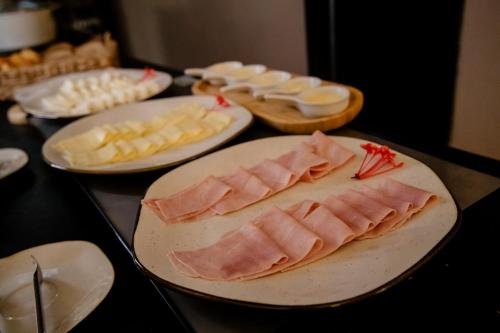 a table topped with plates of meat and other foods at Pousada Yamandu - Piscinas Aquecidas in Juquei