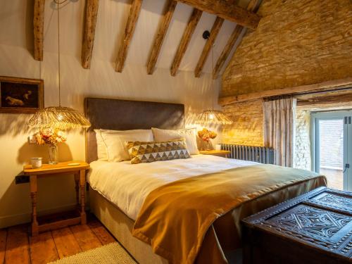 a bedroom with a large bed and a window at The Barns at Stoneythorpe in Southam