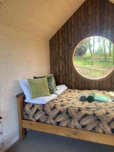 a bed in a room with a round window at Sugi wooden pod in York
