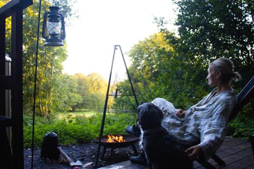 a woman sitting in a hammock with a dog at Sugi wooden pod in York