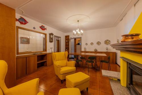 un soggiorno con tavolo e sedie gialle di La Terrazza sui Monti a Castiglione dʼIntelvi
