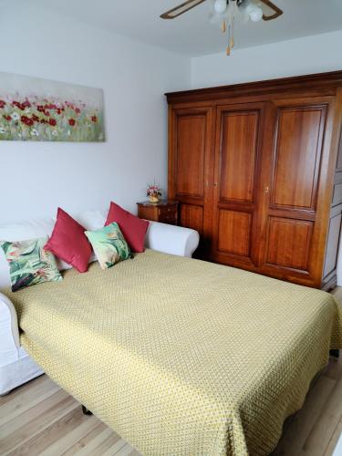 1 dormitorio con 1 cama y armario de madera en Studio indépendant location courte durée à proximité de Lycée International en Saint-Germain-en-Laye