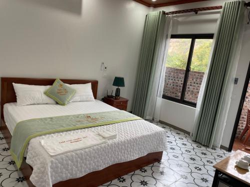 Schlafzimmer mit einem großen Bett und einem Fenster in der Unterkunft TAM COC HAPPY DAY in Ninh Bình