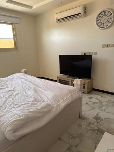 a bedroom with a bed and a flat screen tv at استديو in Unayzah
