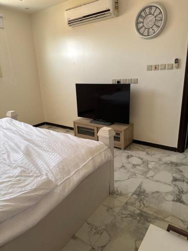 a bedroom with a bed and a flat screen tv at استديو in Unayzah