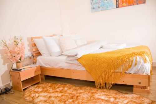 a bedroom with a bed with a orange blanket on it at Adeti Homestay in Ruiru