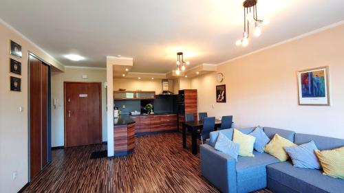 un soggiorno con divano blu e una cucina di Apartament Modern Life w centrum z parkingiem a Jelenia Góra