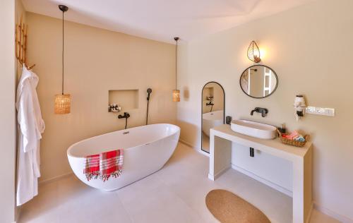 a bathroom with a large tub and a sink at Kairos Hotel in Kaş