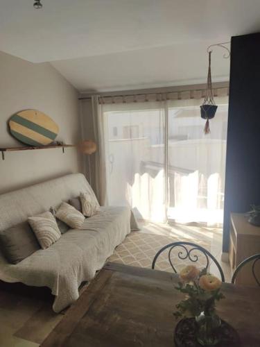 un salon avec un canapé et une table dans l'établissement Appartement au calme, à Canet