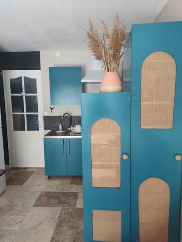 une cuisine avec des armoires bleues et un évier dans l'établissement Appartement au calme, à Canet