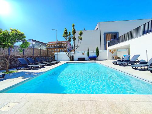 a swimming pool with lounge chairs and a building at Casa do Salgueiral Douro in Peso da Régua