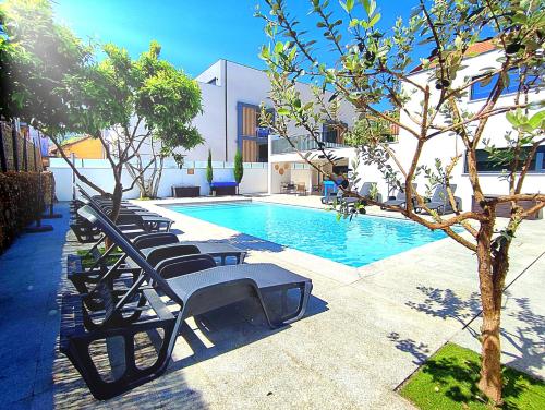 a row of lounge chairs next to a swimming pool at Casa do Salgueiral Douro in Peso da Régua