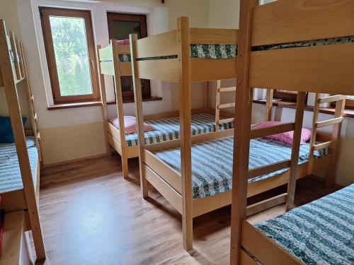 a room with four bunk beds and a window at Dom Klementa Juga in Lepena