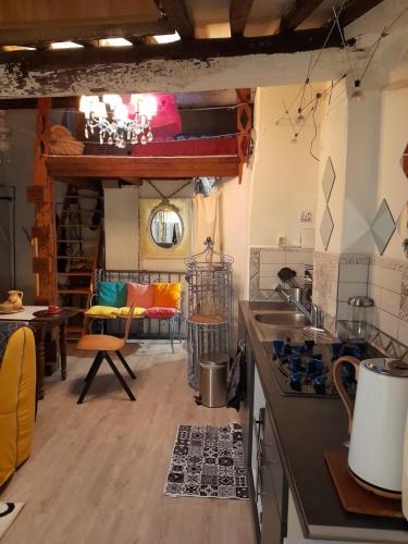 une cuisine avec un évier et une cuisinière dans une pièce dans l'établissement La Bohème, à Narbonne