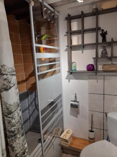 une douche avec une porte vitrée dans une salle de bain dans l'établissement La Bohème, à Narbonne