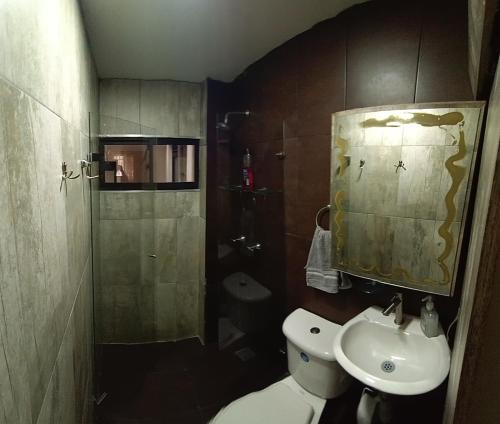 małą łazienkę z toaletą i umywalką w obiekcie descanso w mieście Medellín
