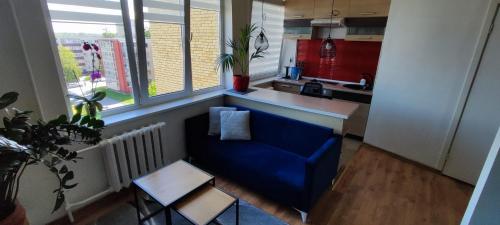 a living room with a blue couch in a kitchen at R&J Apartment II in Panevėžys