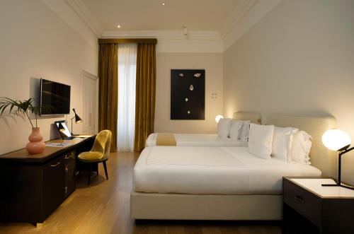 a hotel room with a large bed and a desk at Elizabeth Unique Hotel | a Member of Design Hotels™ in Rome