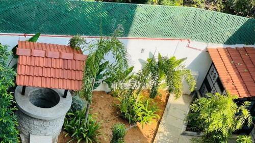 a garden with a toilet and trees and a building at Mayilveedu Guest House in Tuticorin