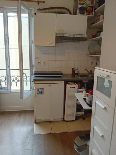 une cuisine avec un évier et un réfrigérateur dans l'établissement París 10, à Paris