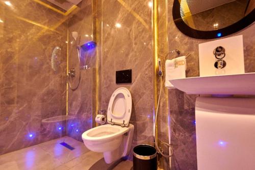 a bathroom with a toilet and a shower and a sink at MEETHAQ HOTELS MAITAMA in Abuja
