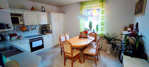 a kitchen with a wooden table and chairs in it at Haus am Park in Steinhagen